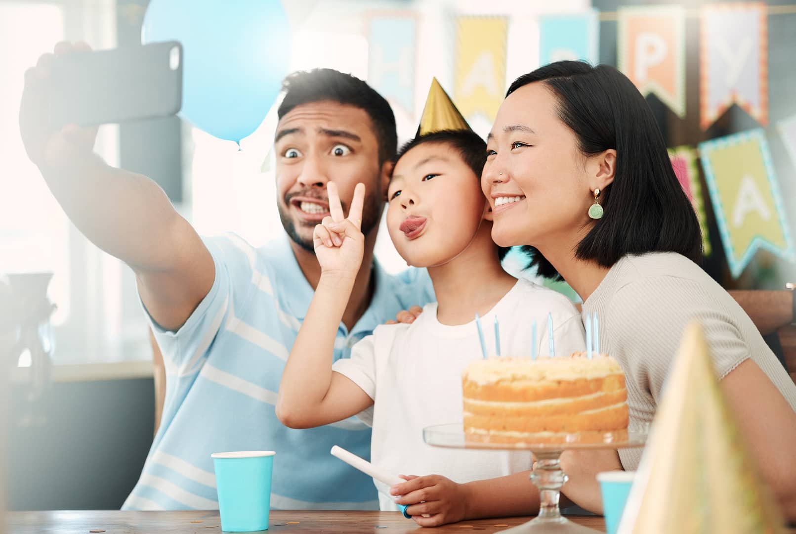 Shot of a happy family taking selfies while celebrating a birthday at home